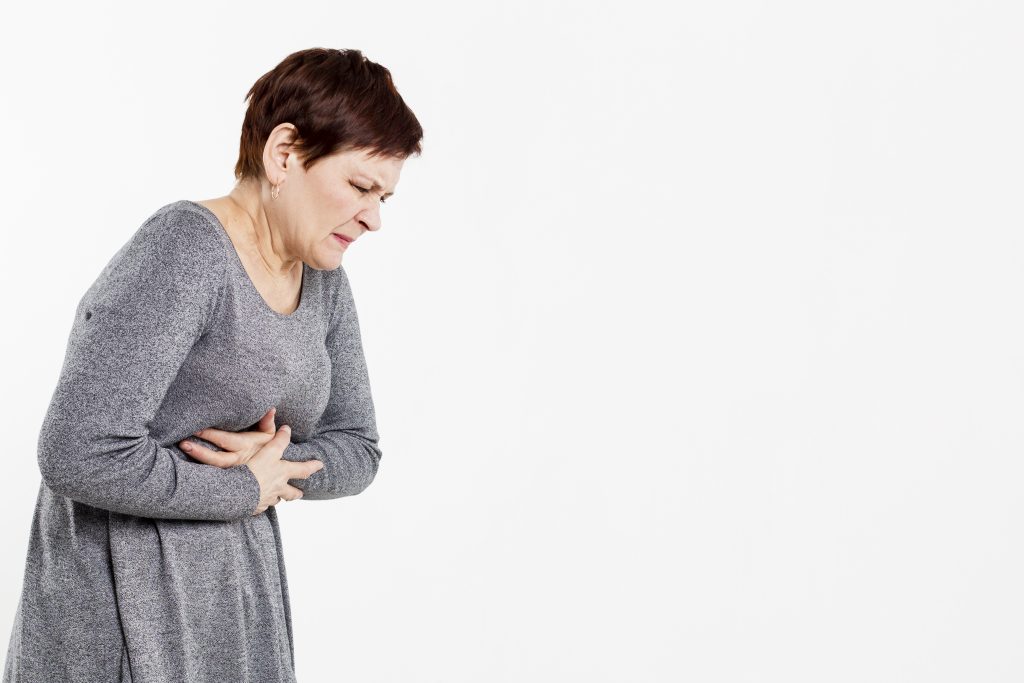 Senior woman clutching her stomach in pain